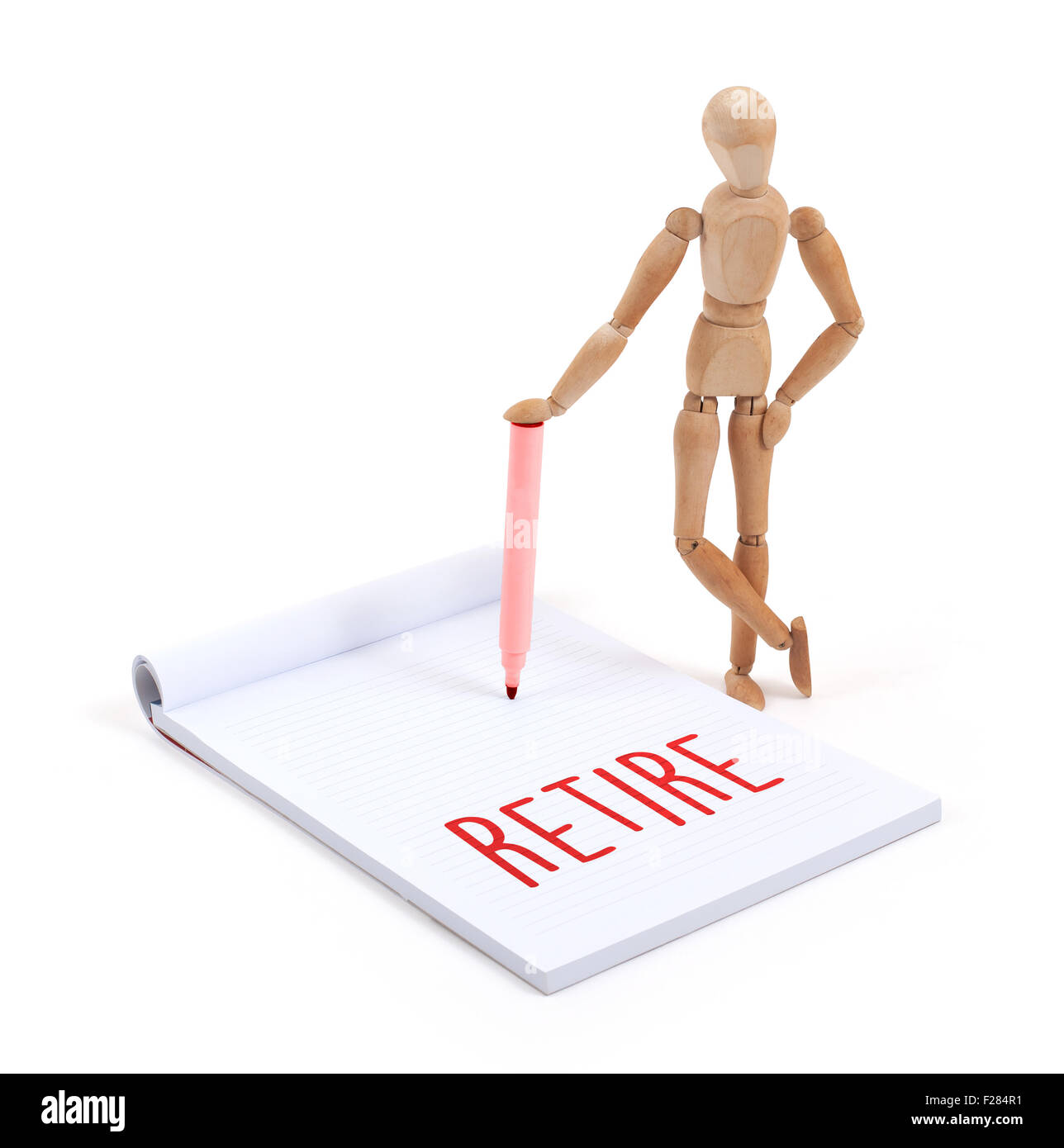 Wooden mannequin writing in a scrapbook - Retire Stock Photo