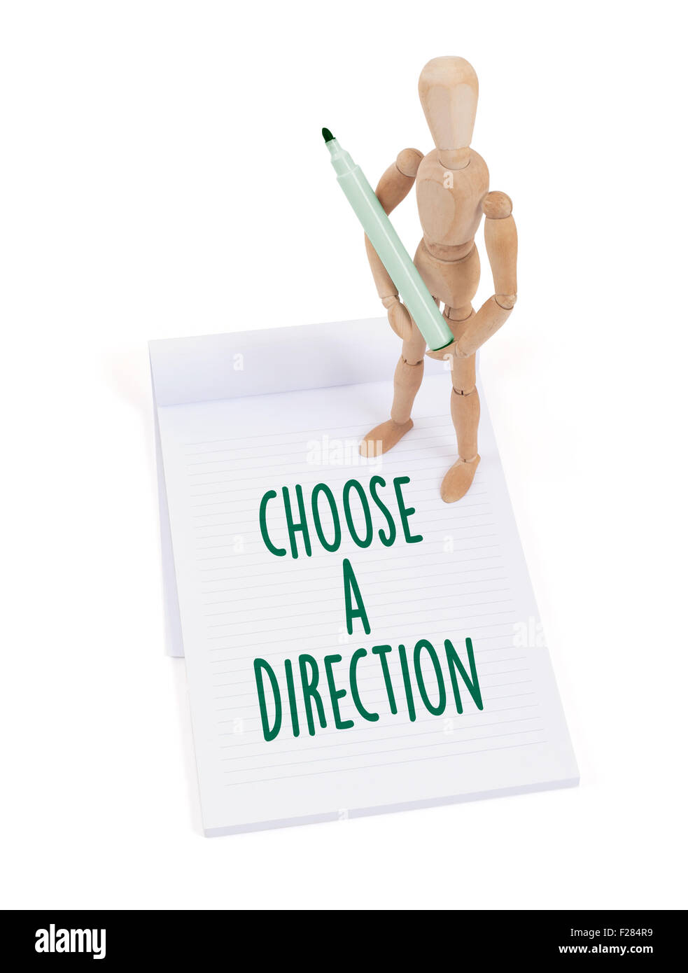 Wooden mannequin writing in a scrapbook - Choose a direction Stock Photo