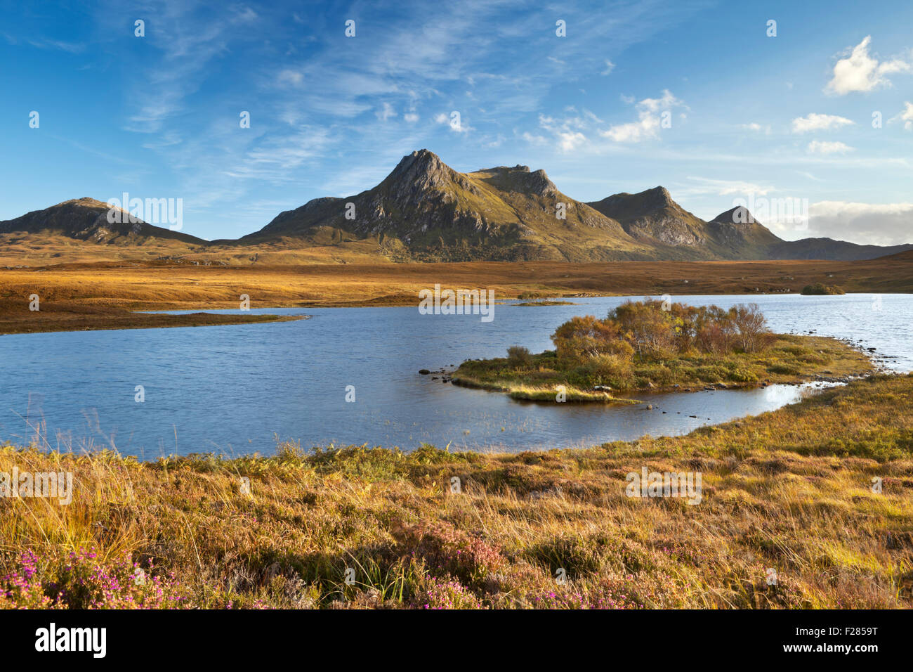 The mountain range of Ben Loyal with the loch below, in late afternoon sunlight. Stock Photo