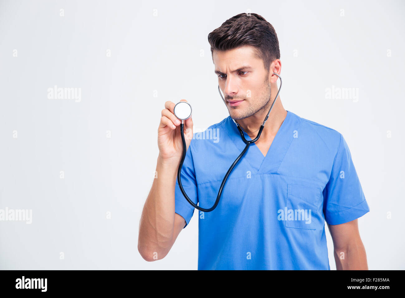 Portrait of a male doctor holding stethoscope isolated on a white ...