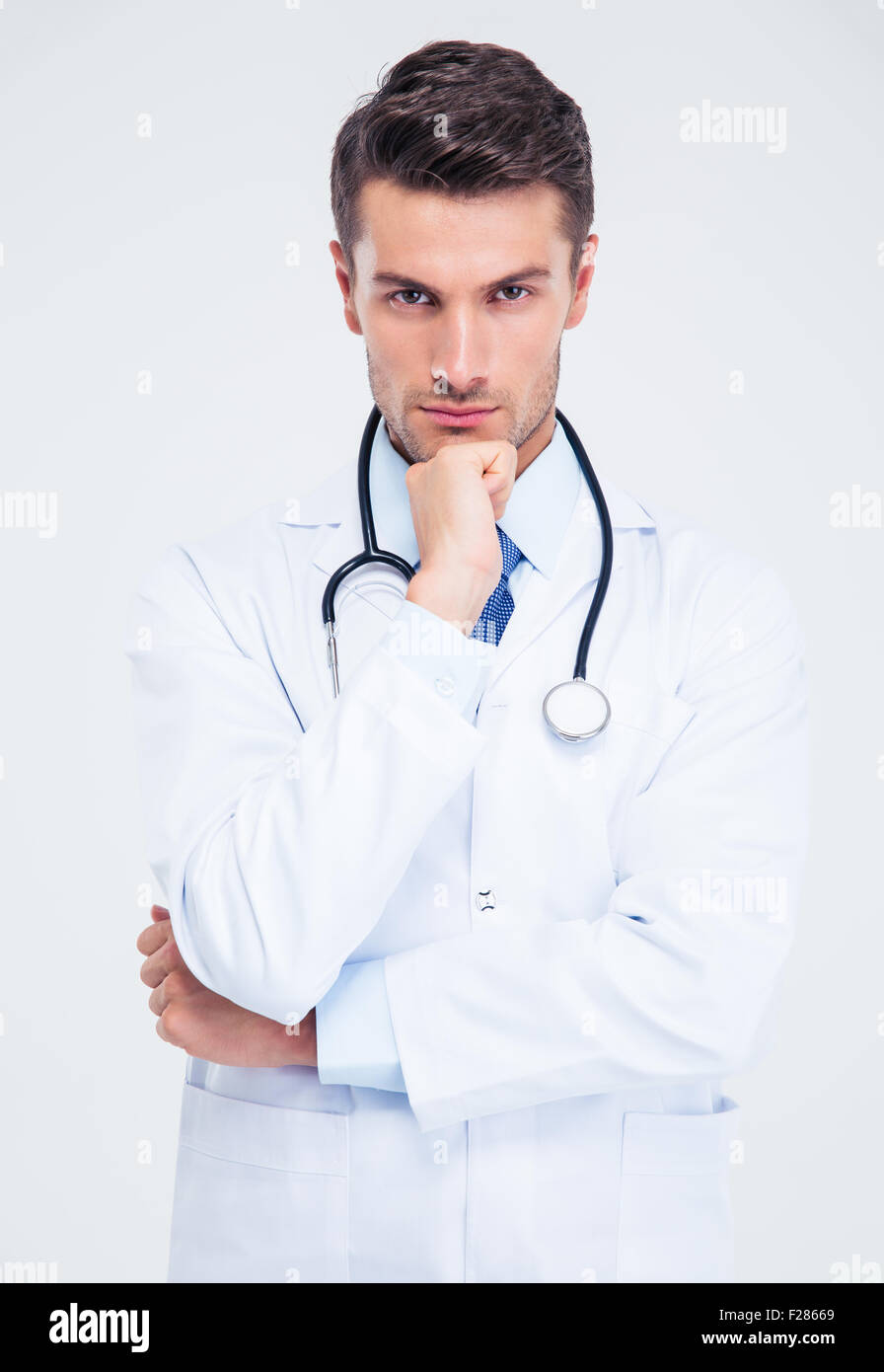 Portrait of a pensive male doctor looking at camera isolated on a white ...