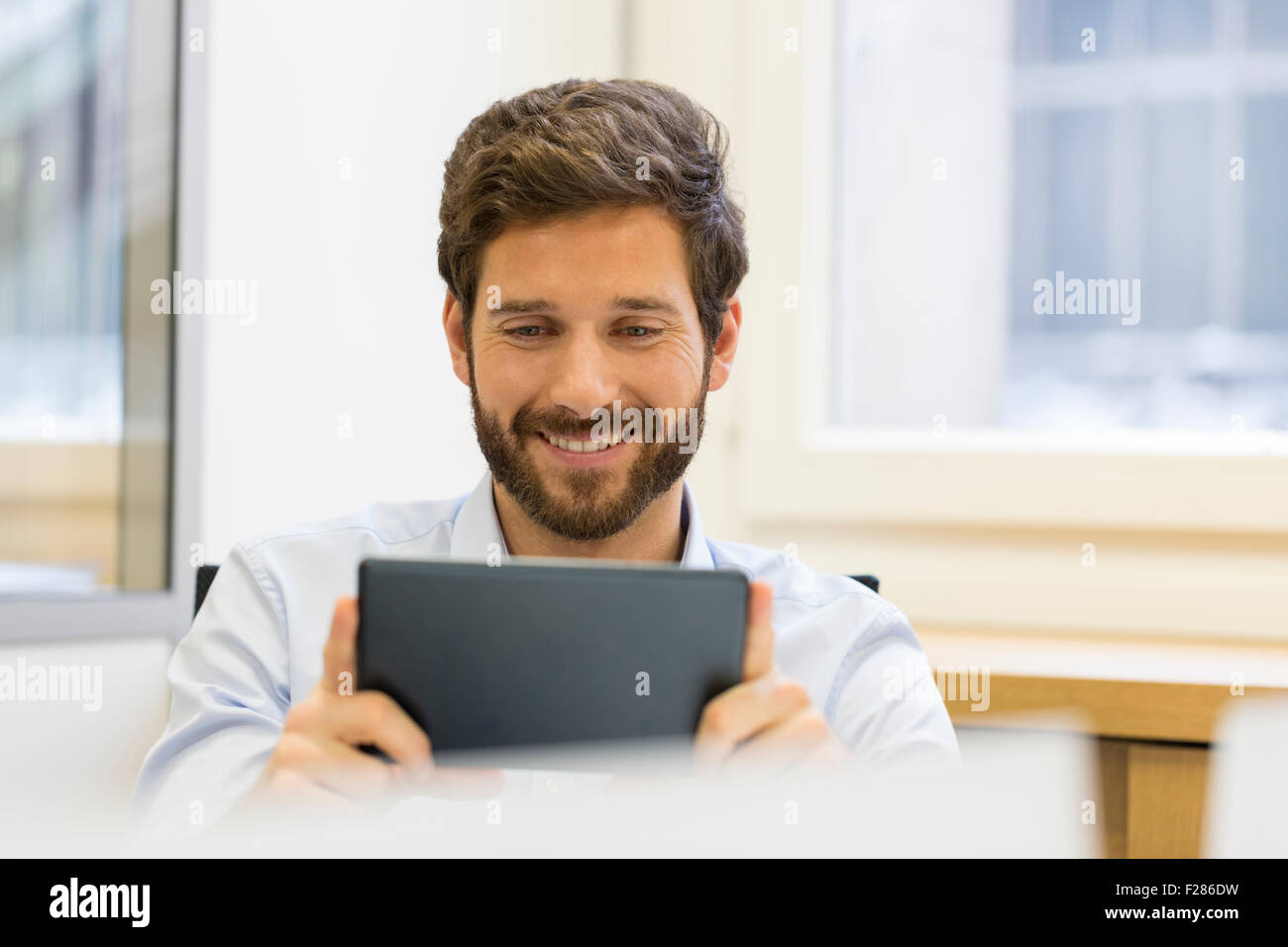 Cheering businessman in office using digital tablet Stock Photo