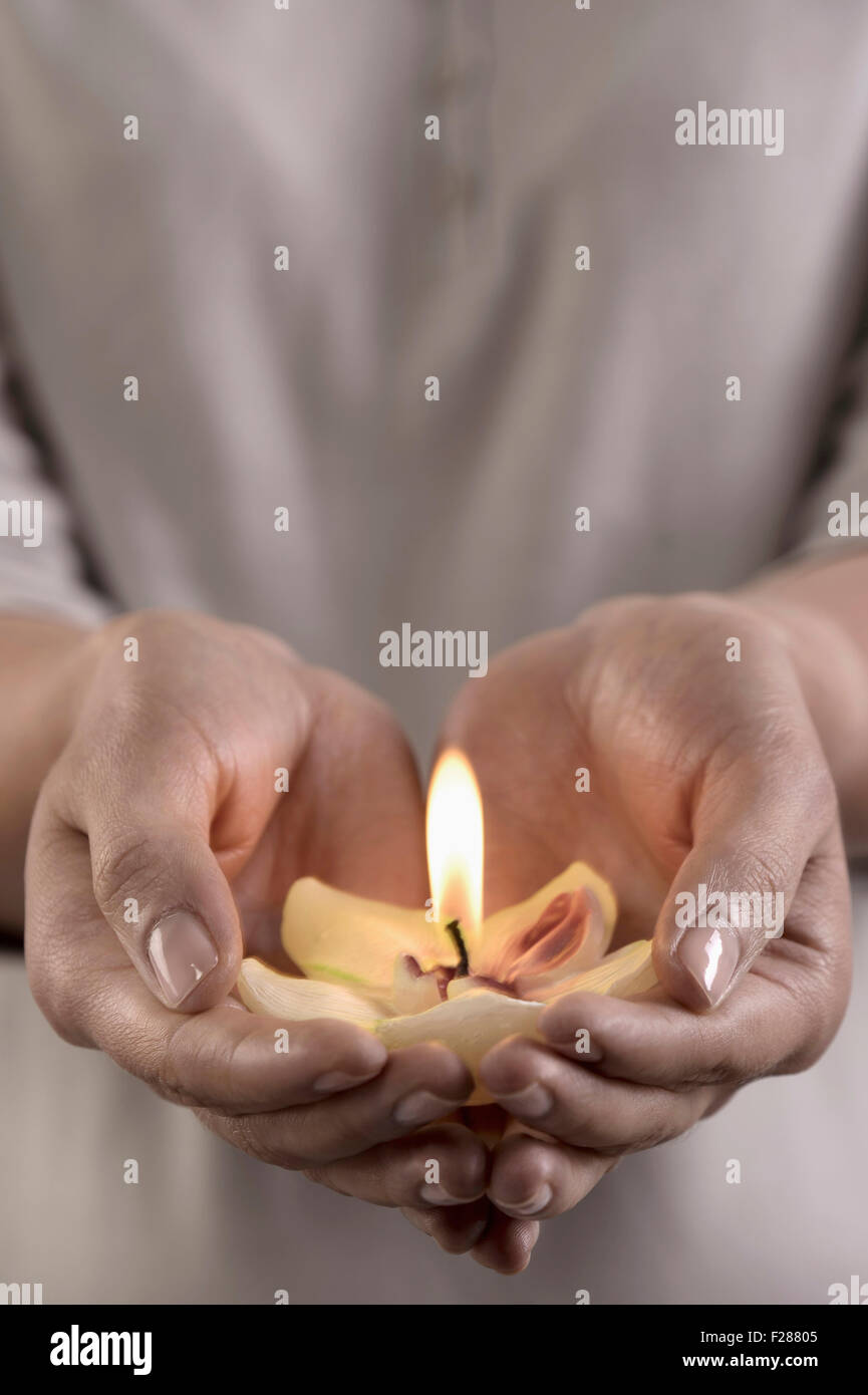 Woman holding burning candle in hands, Bavaria, Germany Stock Photo