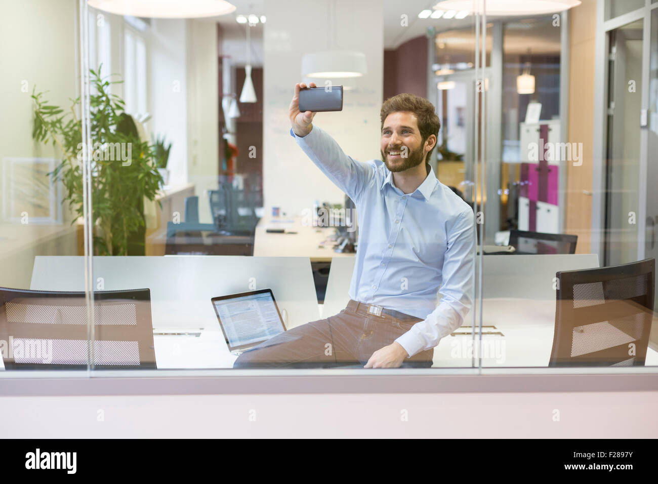 Selfie casual businessman taking pictures in open space office Stock Photo
