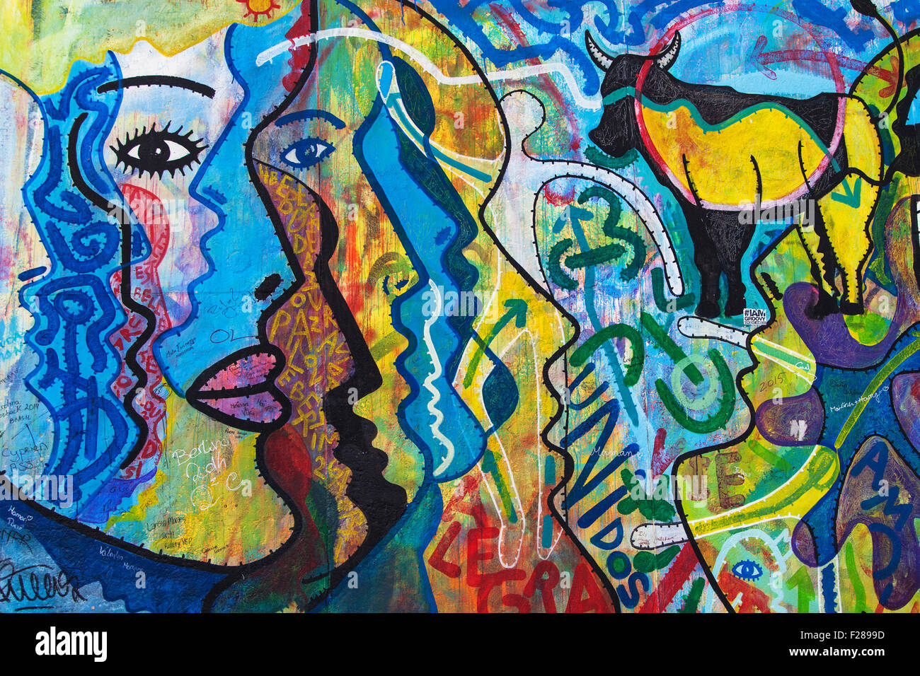 Faces in the mural 'O Povo Unido Nunca Mais Sera Veicido' by Kim Prisu on the East Side Gallery on August 8, 2015 in Berlin Stock Photo