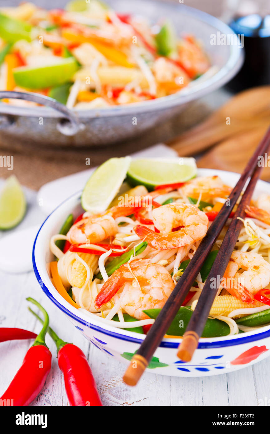 A healthy stir-fry of shrimp and vegetables served over noodles. Stock Photo