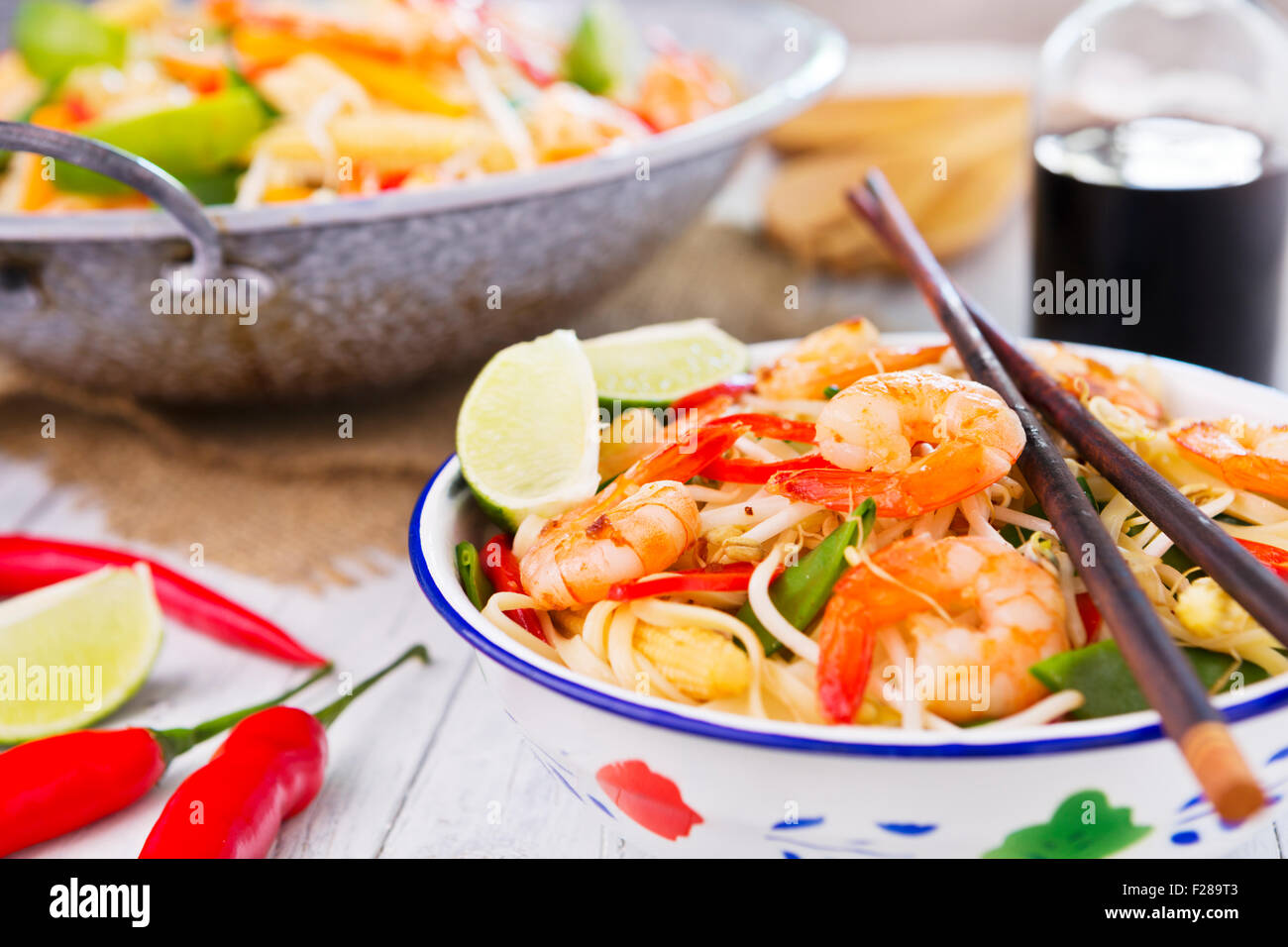 A healthy stir-fry of shrimp and vegetables served over noodles. Stock Photo