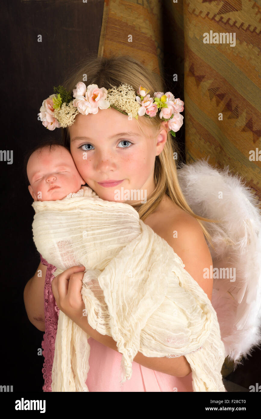 Pink little girl playing an angel in a Christmas nativity scene with a