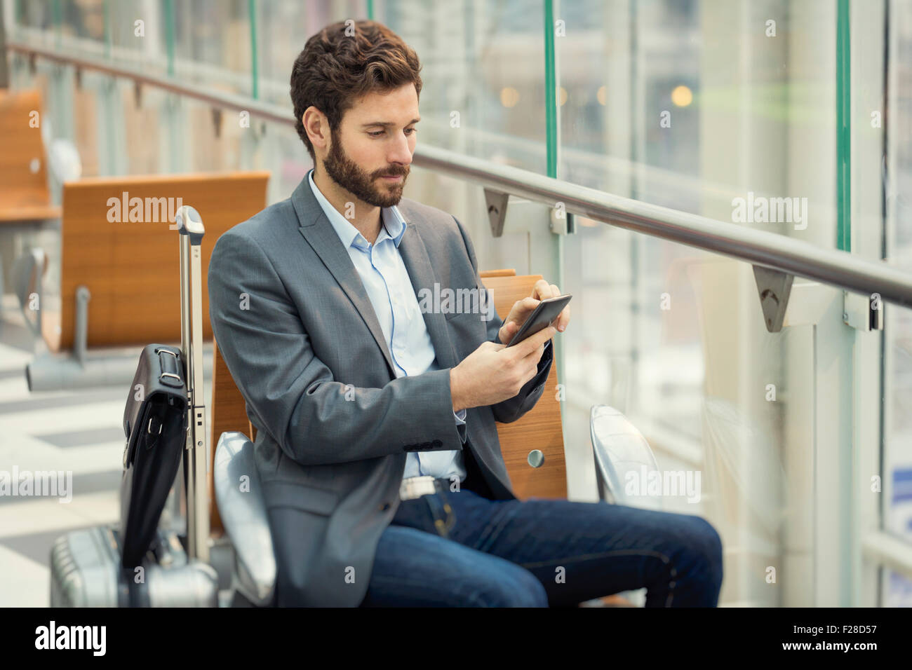 Man in the hall airport. Typing text message on mobile phone Stock Photo
