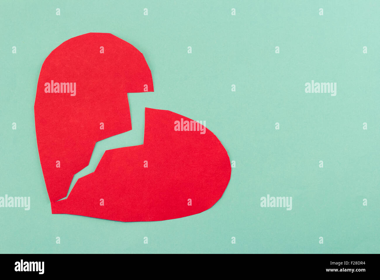 close up of paper broken heart on blue background Stock Photo