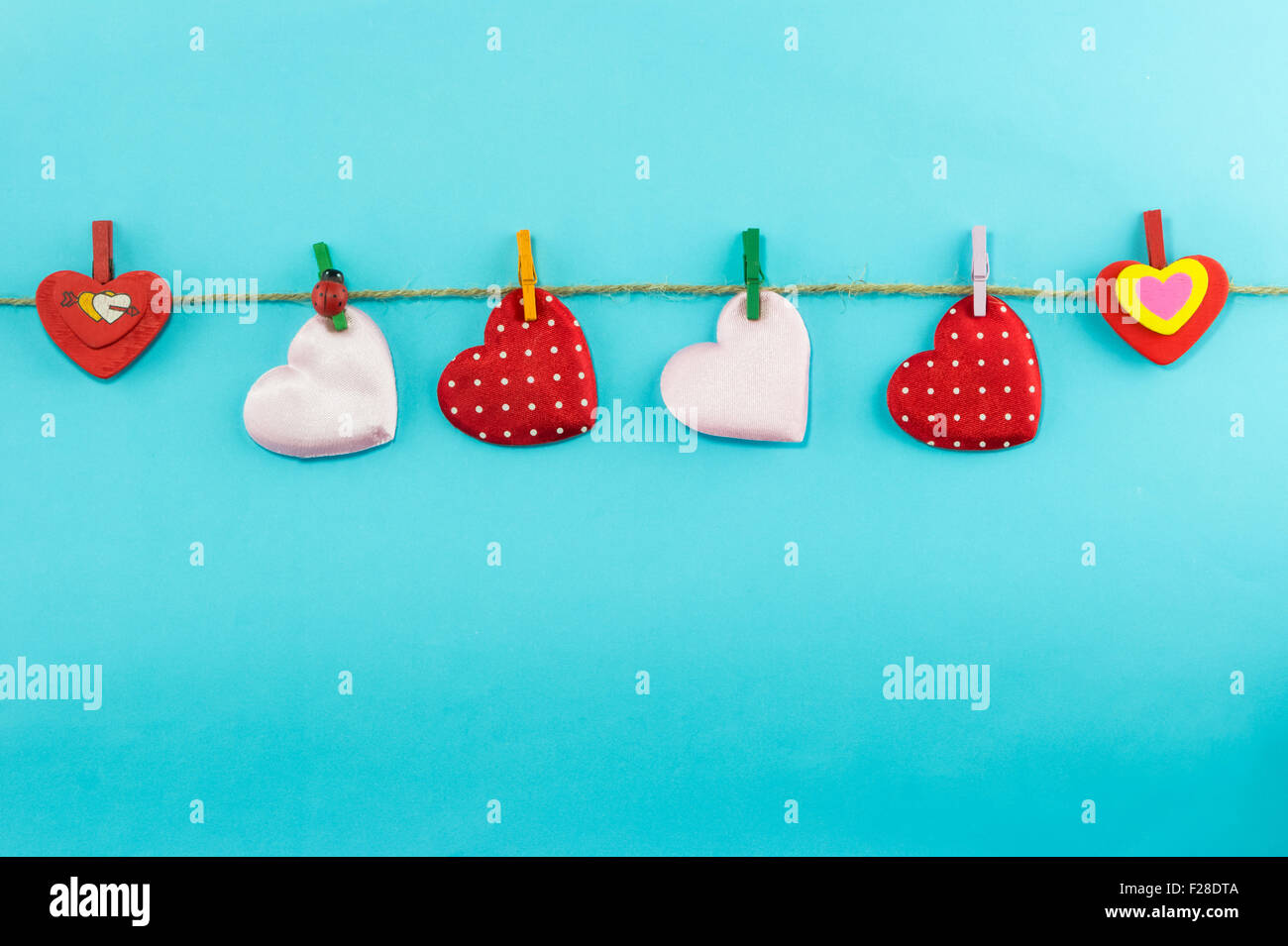Cotton hearts hanging over blue background Stock Photo Alamy