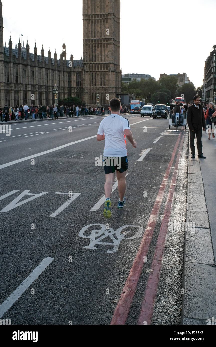 a lone runner on Westminster bridge London running in the cycle lane Stock Photo