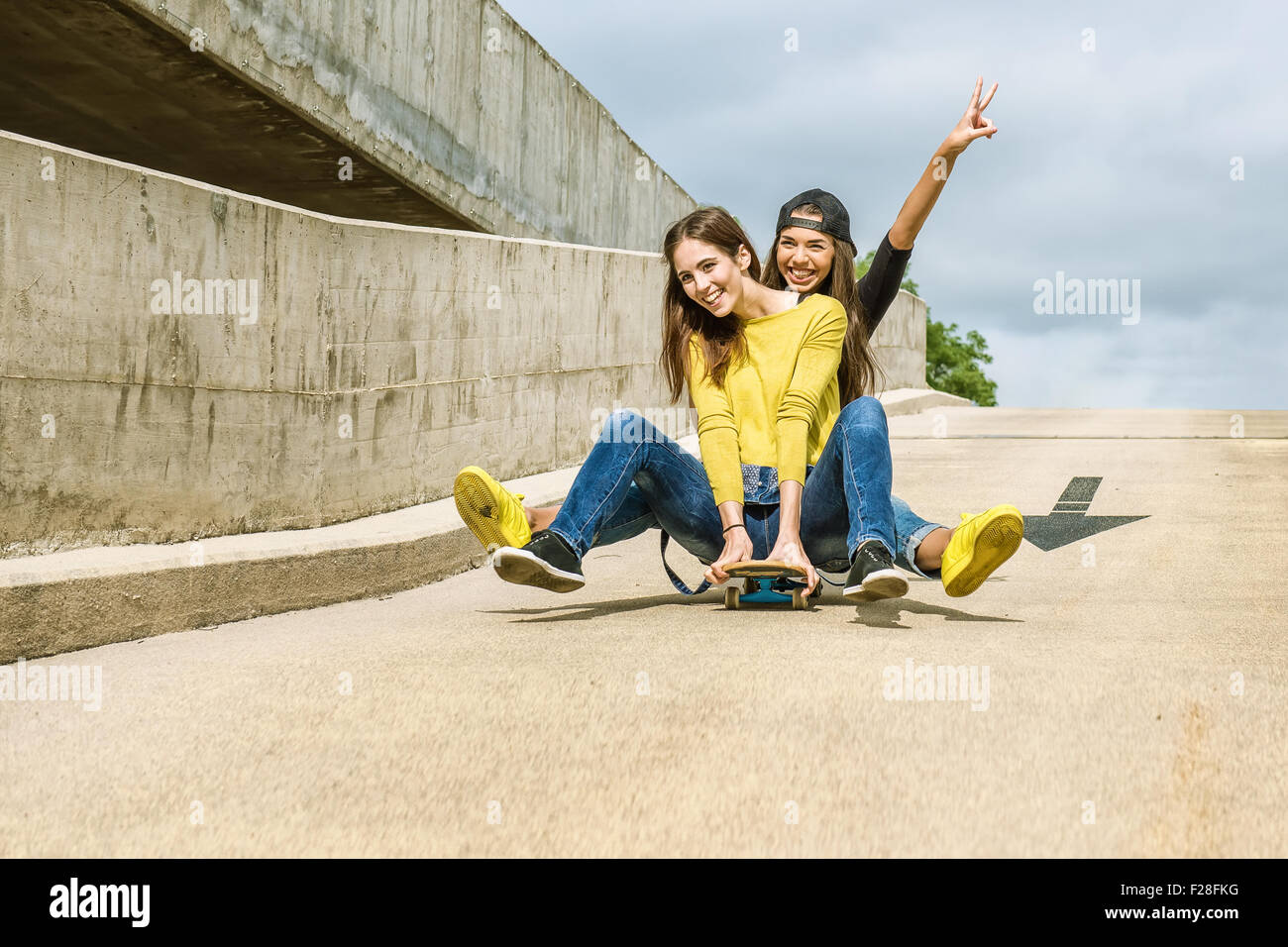 Skateboarder girlfriends roll down the slope Stock Photo