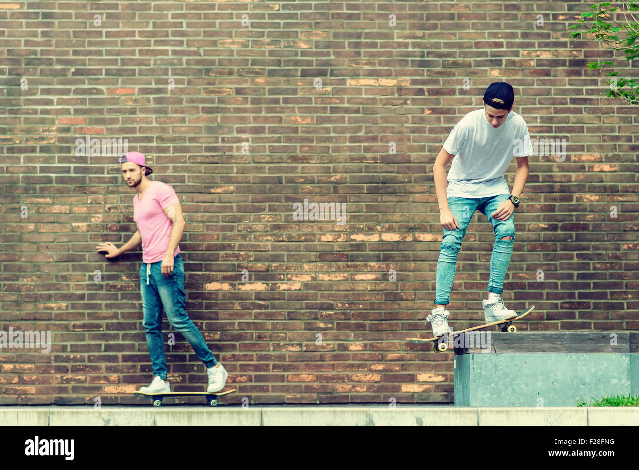 Skateboarder boys by brick wall Stock Photo Alamy