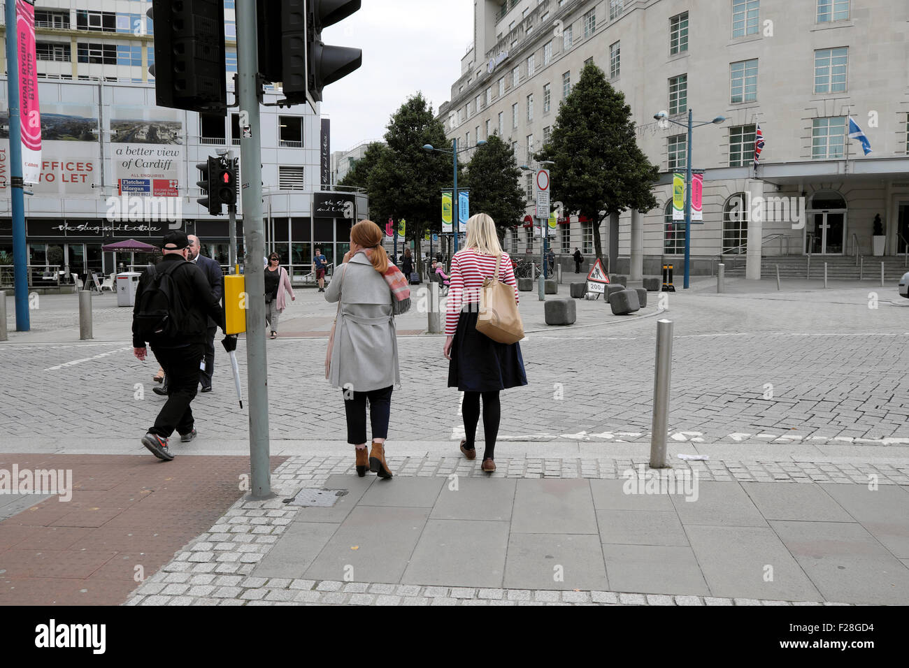 Women waiting to cross the street at traffic lights in Cardiff, South ...