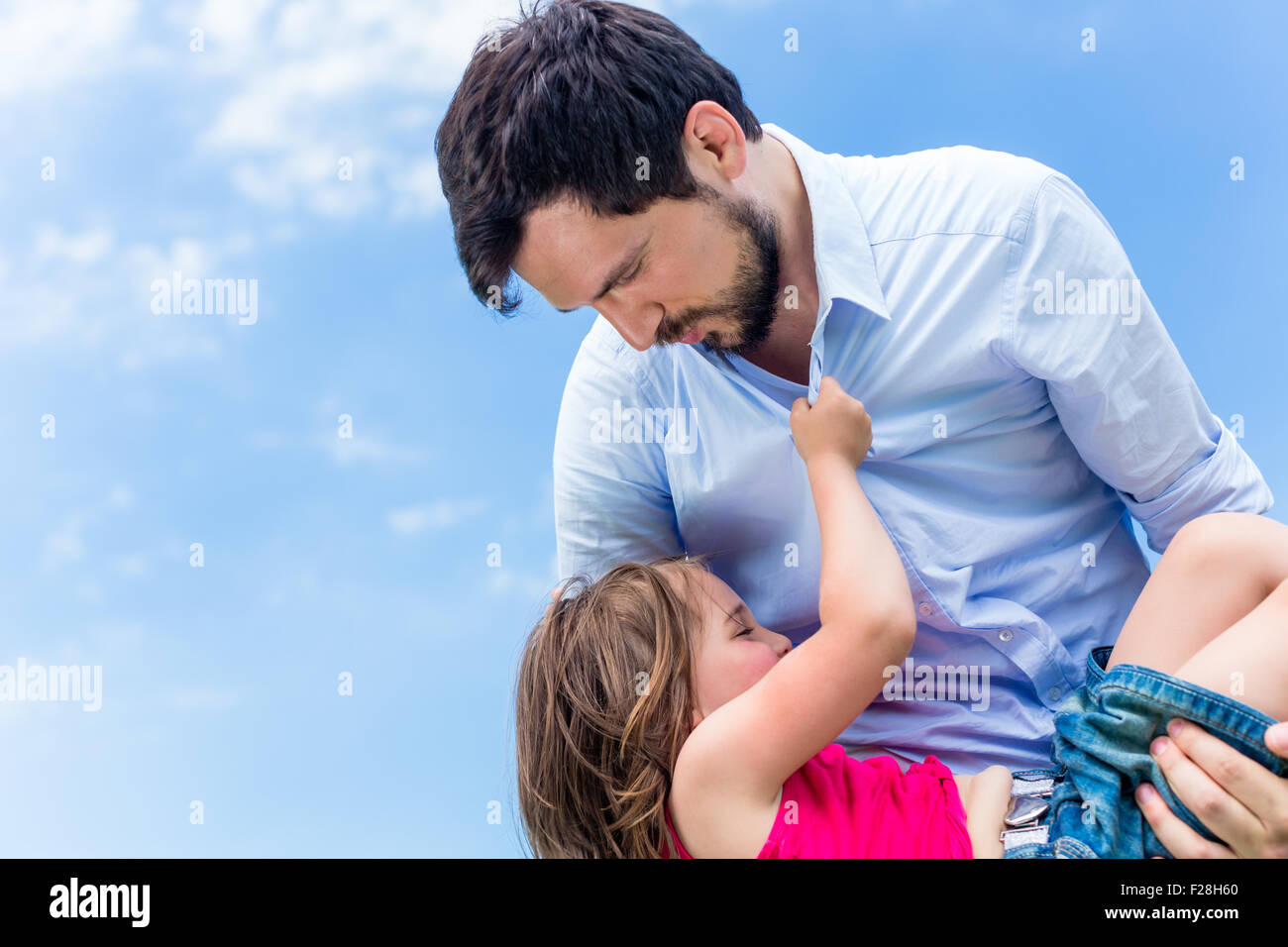 Father carrying daughter in his hands protecting her Stock Photo