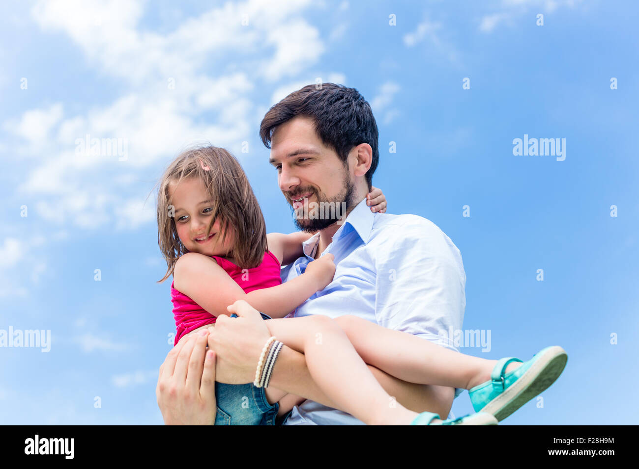 Father carrying daughter in his hands protecting her Stock Photo