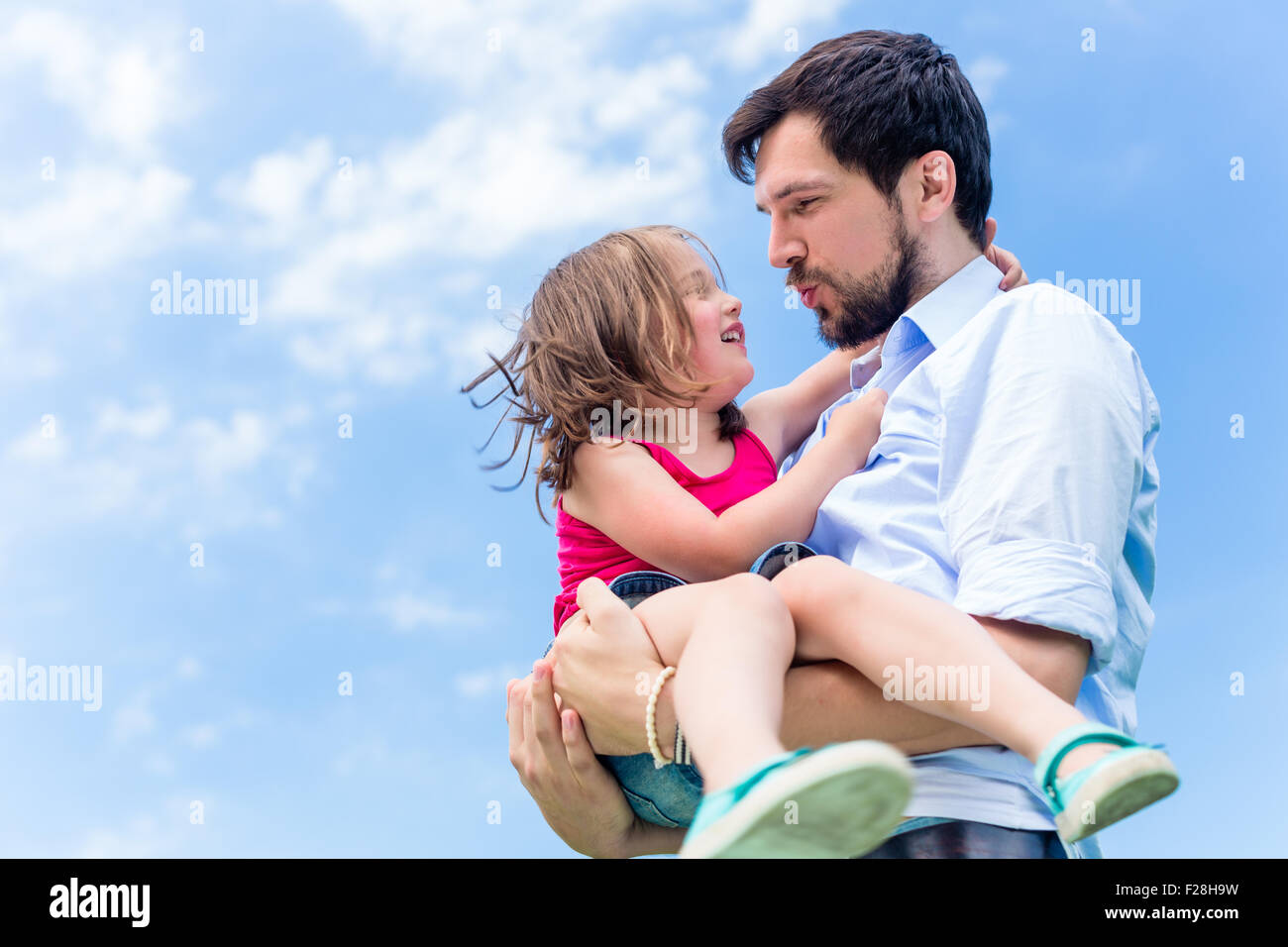 Father carrying daughter in his hands protecting her Stock Photo