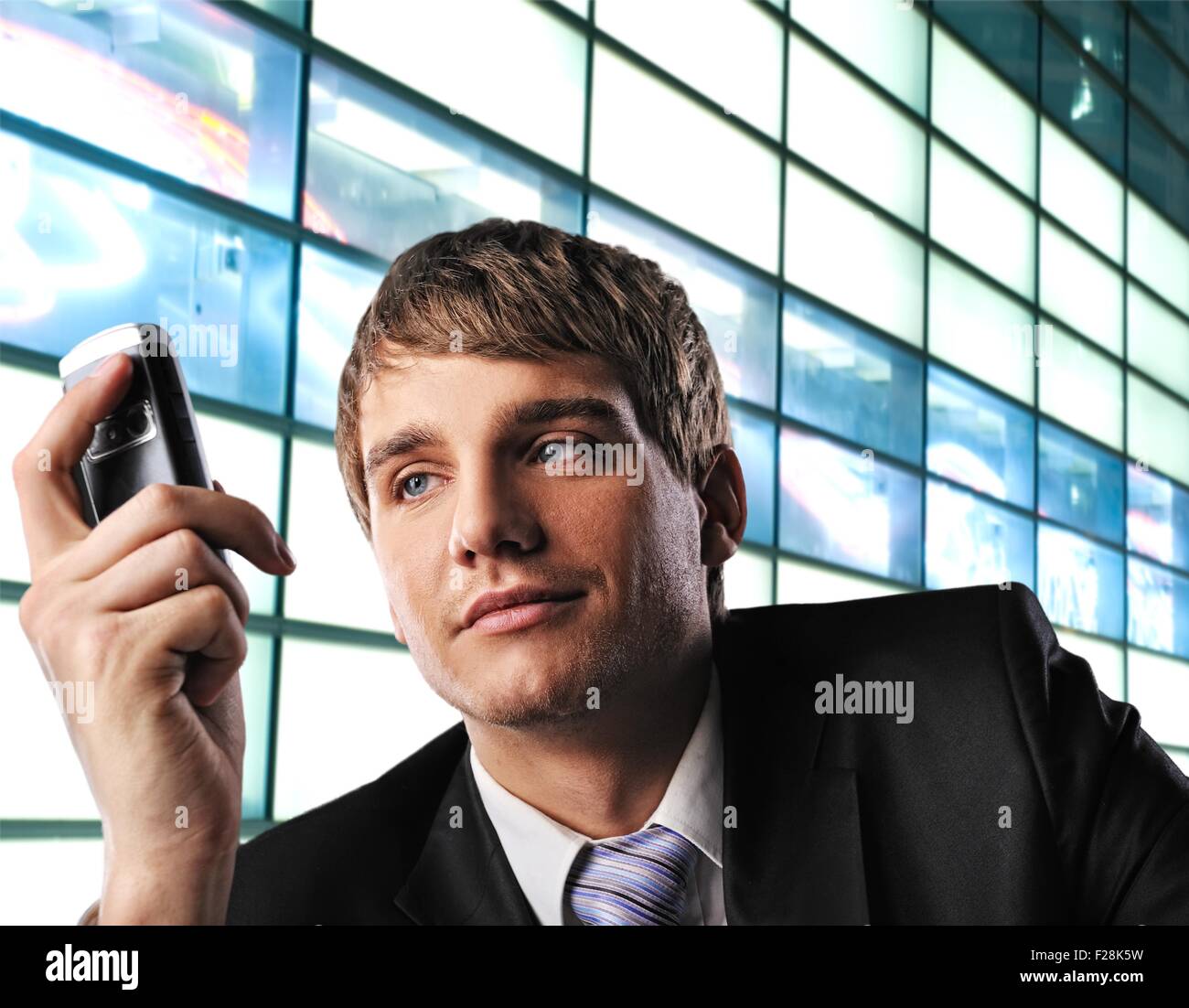 Young businessman with mobile phone over abstract background Stock Photo