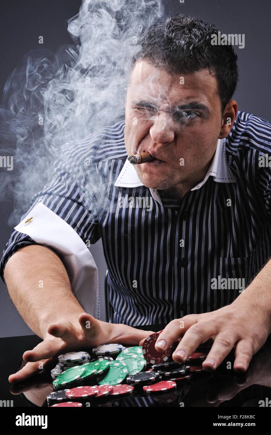 Portrait of a young gangster smoking and playing poker Stock Photo