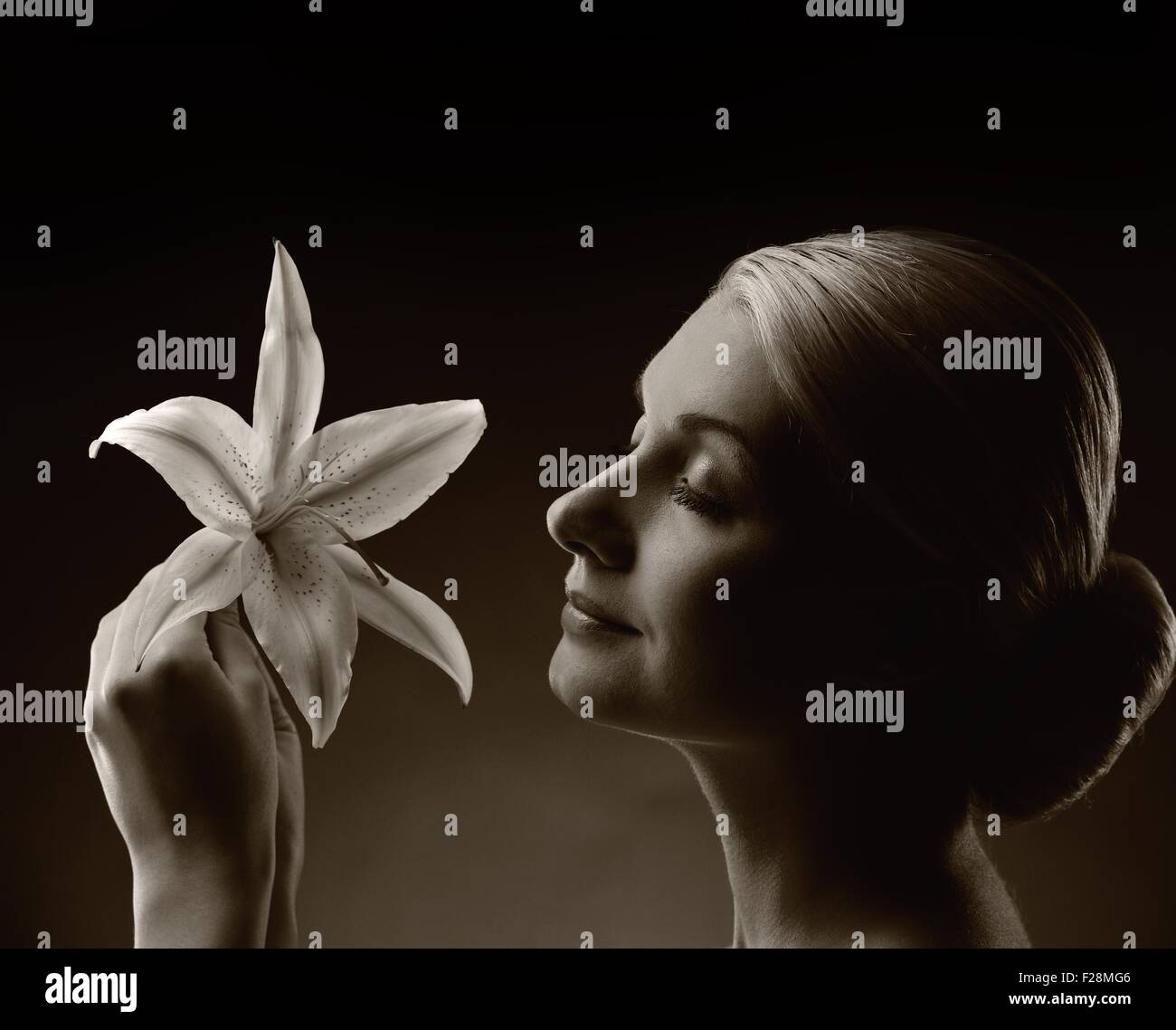 Monochrome picture of a beautiful woman with lily flower Stock Photo