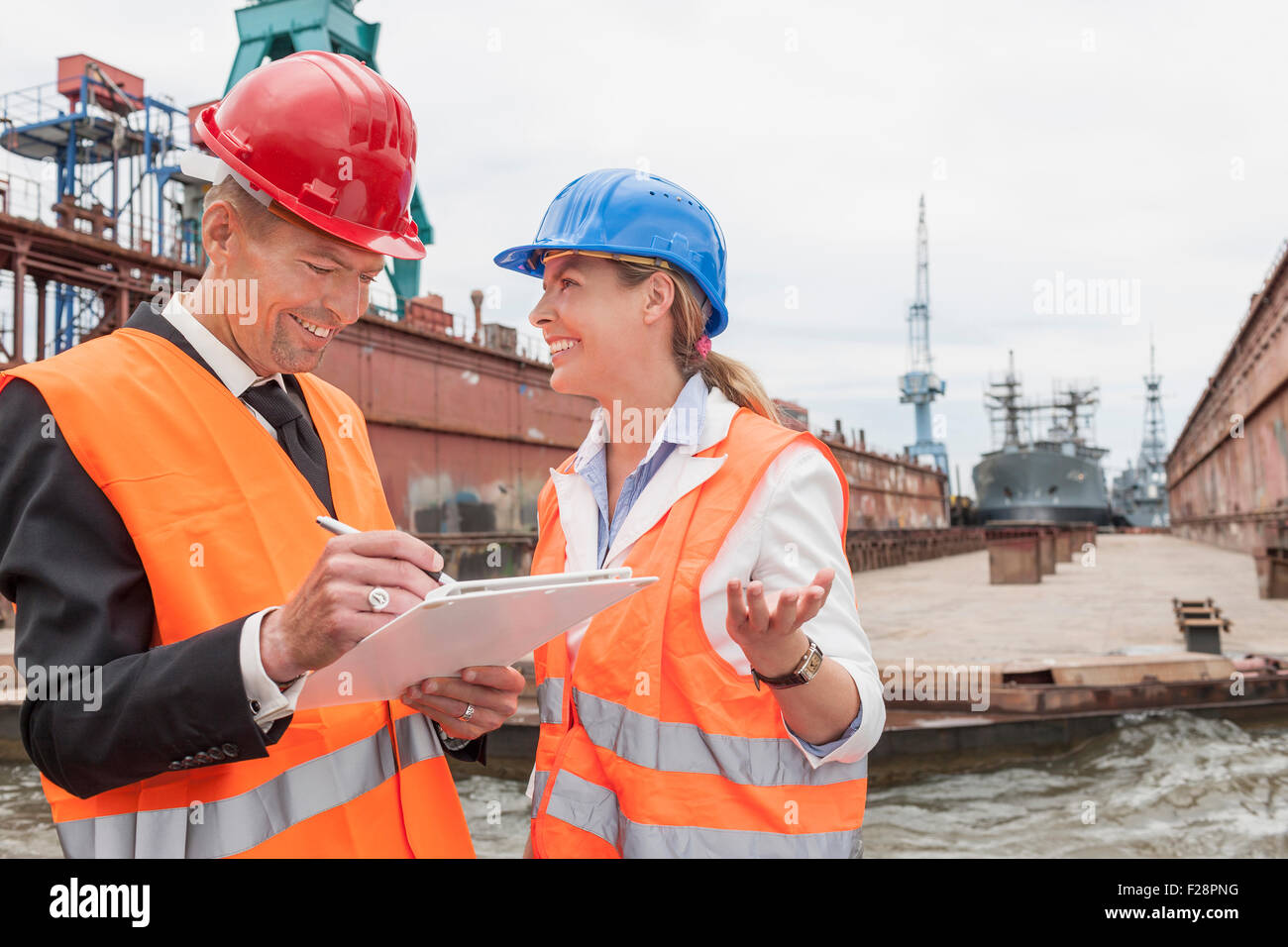 Dockers explaining to a manager during inspection of an industrial harbour, Hamburg, Germany Stock Photo