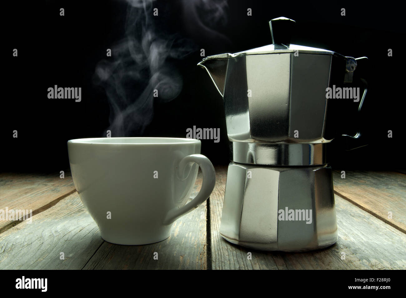 Italian coffee maker next to a hot beverage Stock Photo