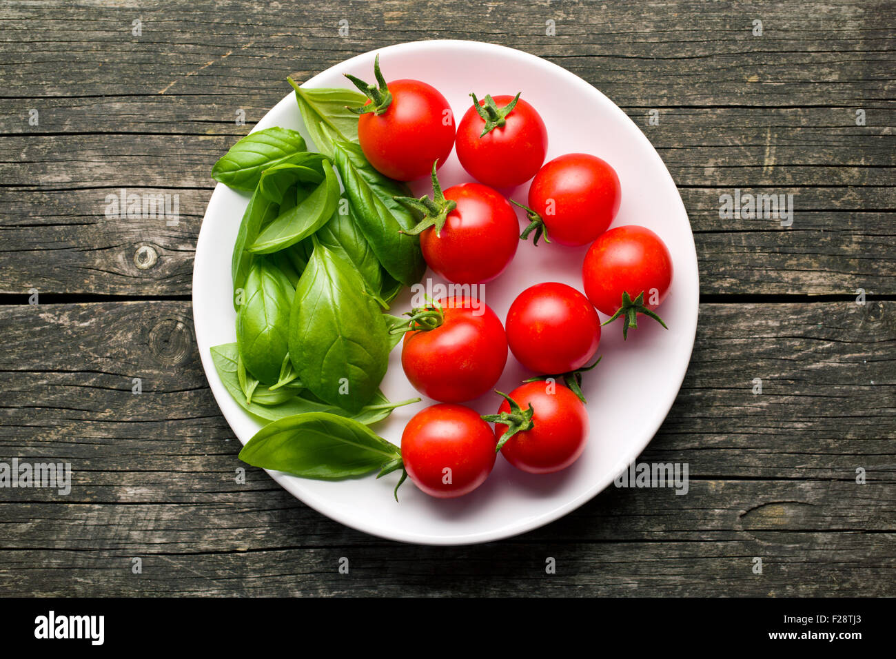 tomatoes and basil leaves on plate Stock Photo - Alamy