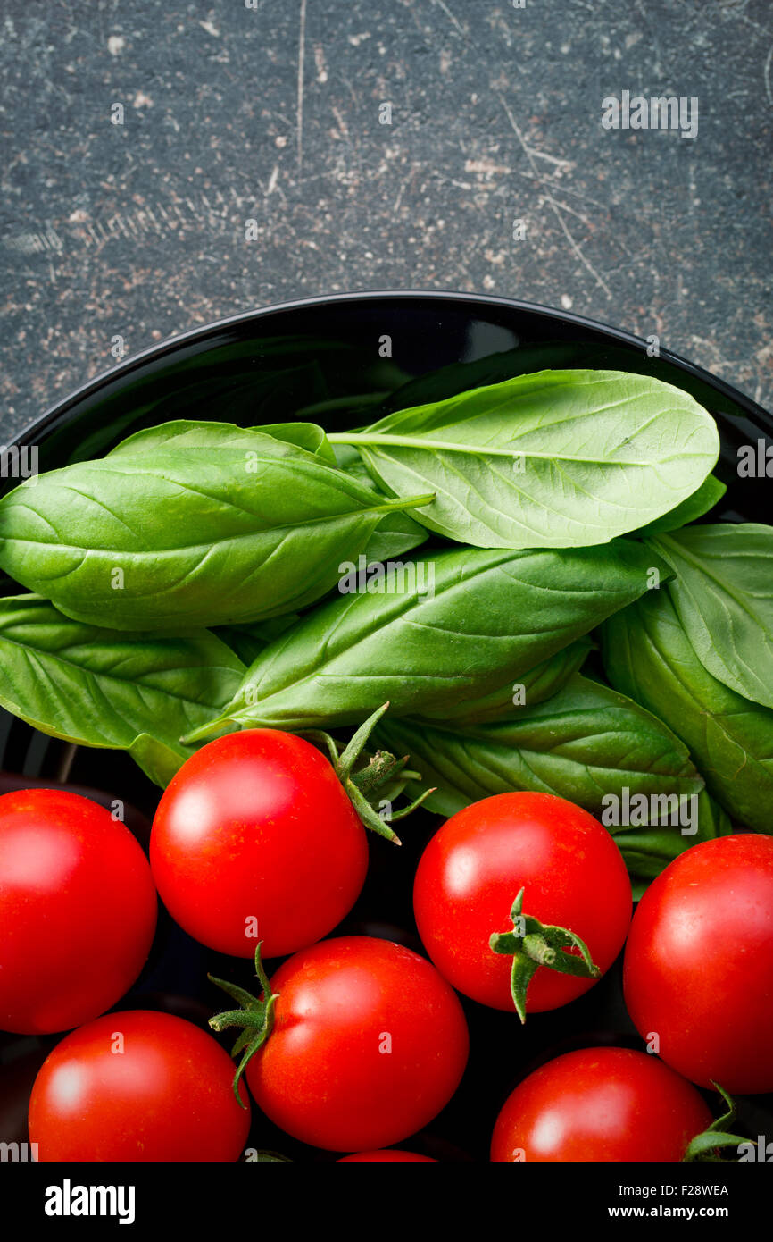 tomatoes and basil leaves on kitchen table Stock Photo - Alamy