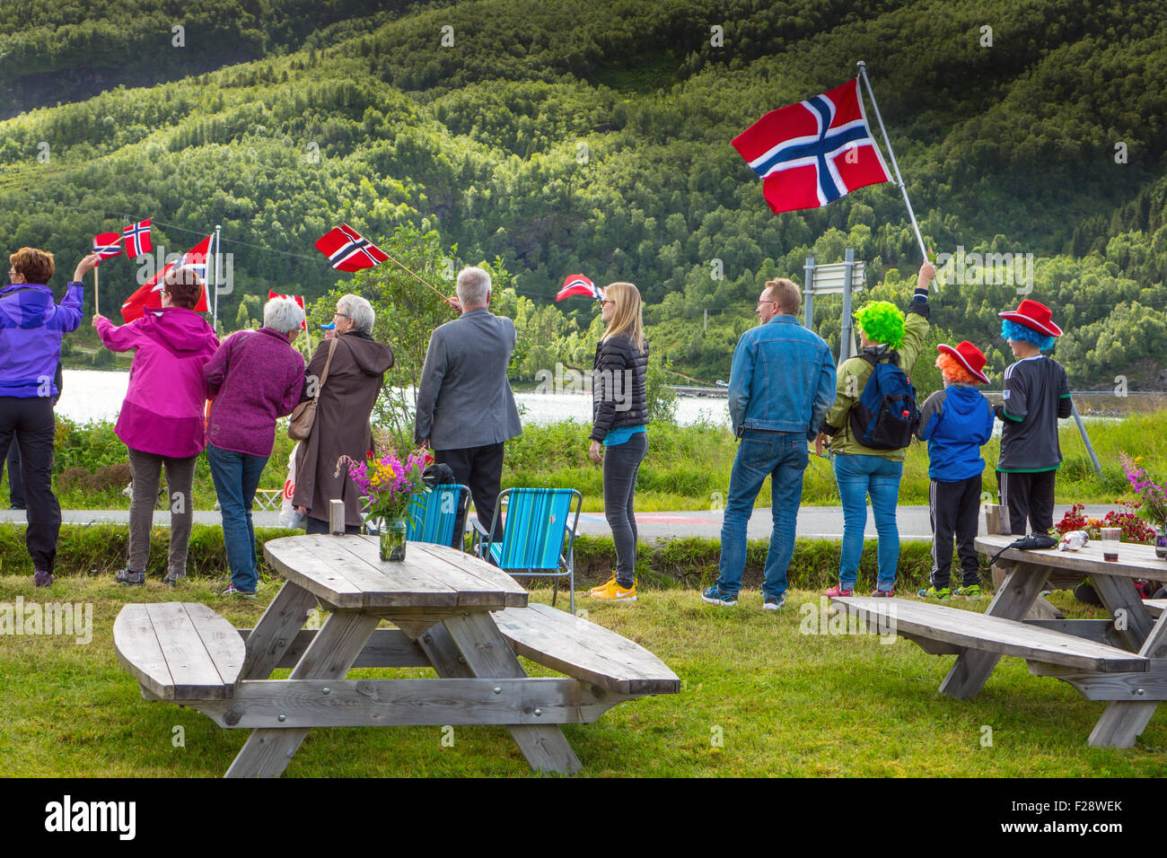 Spectators at Arctic Cycle Race of Northern Norway, Norwegian flags, cloudy skies, Stock Photo
