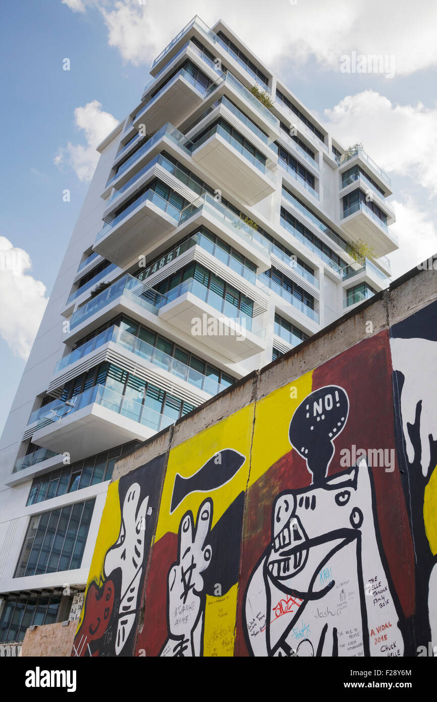 New luxury apartment block built within the former death strip at the East Side Gallery with a section of the Berlin Wall Berlin Stock Photo