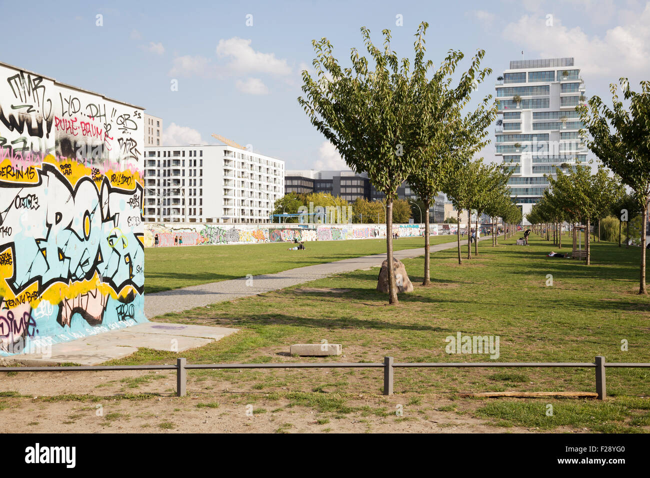 people in the former death strip at the East Side Gallery with a new luxury apartment block behind, Berlin, Germany Stock Photo
