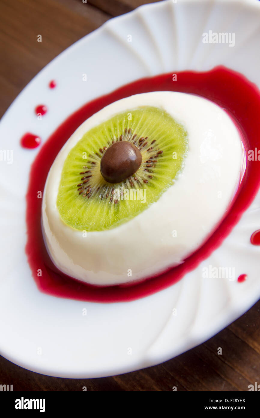 Halloween dessert, bloody eye from vanilla panna cotta and kiwi with