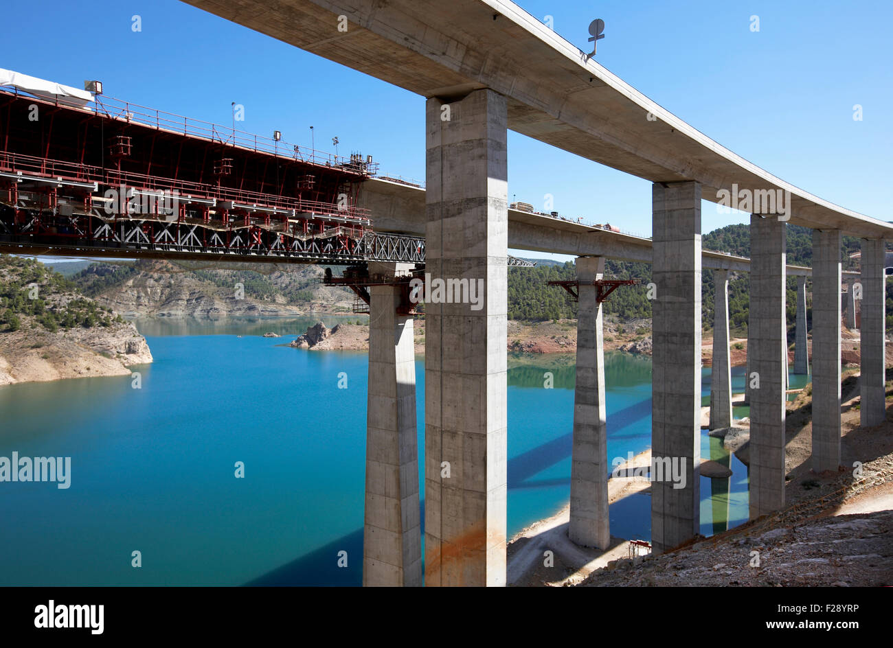 Railway bridge under construction in parallel with highway bridge on landscape blue sky and lake Stock Photo
