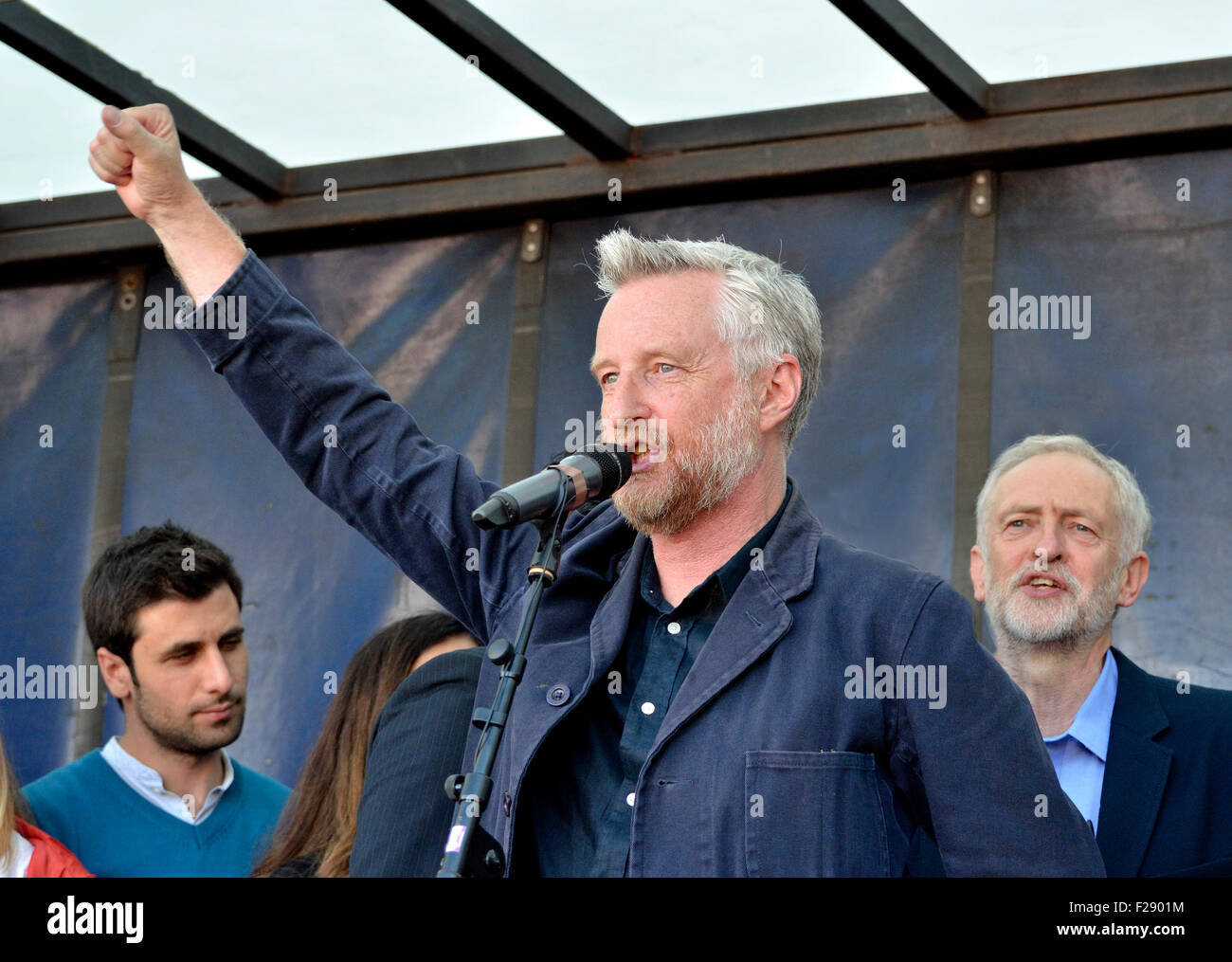 Billy Bragg singing The Red Flag at the 'Refugees Welcome Here' rally in Parliament Square, London 12th Sept 2015. Jeremy Corbyn Stock Photo