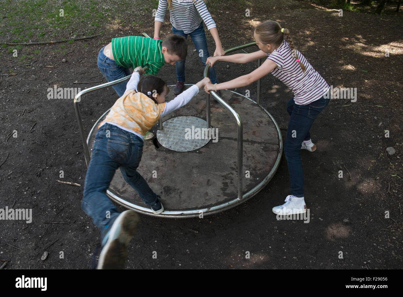 Children having fun on a carousel in playground, Munich, Bavaria, Germany Stock Photo