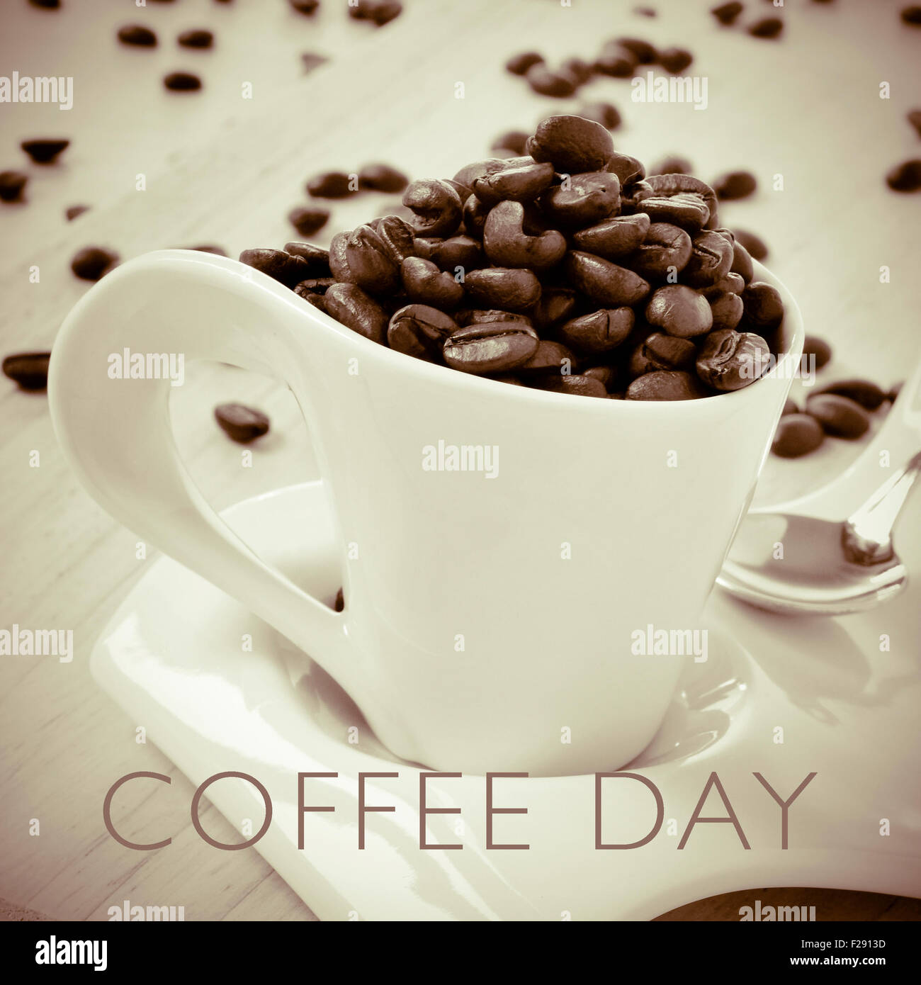 a cup full of roasted coffee beans and the text coffee day, in duotone Stock Photo