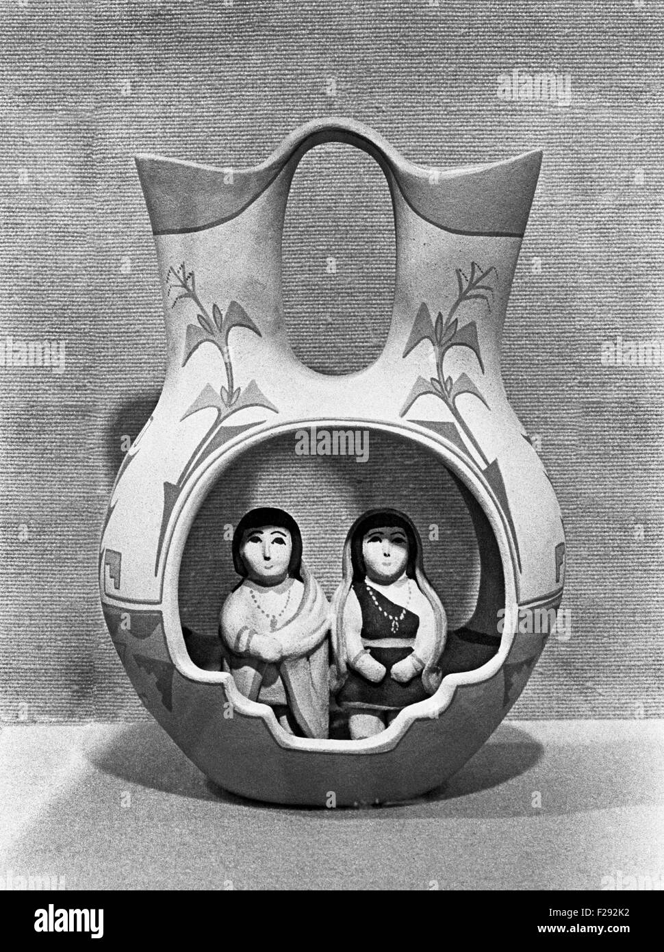 A beautiful wedding vase made by potter Marie Gachupin Romero of Jemez Pueblo, born July 27, 1927, and died in 2007. She had been making pottery of the finest quality for over 50 years. The faces of her figurines are beautifully sculpted and always portray an angelic presence. She most often combined matte-paint and stone-polished slip in the same piece. Her specialty was figurative pottery, primarily storytellers and nacimientos. Stock Photo