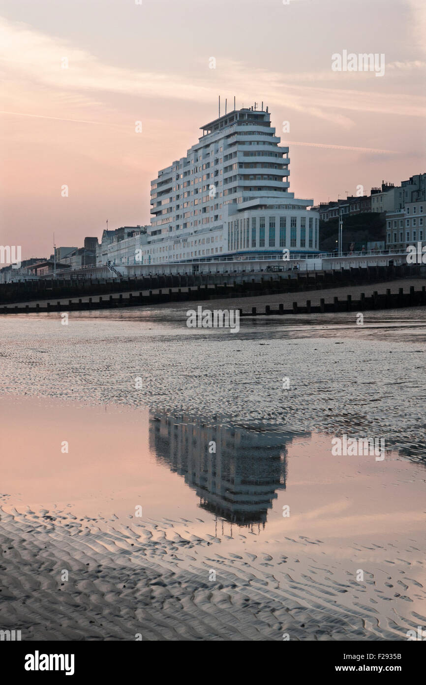 Marine Court, a 1930's art deco buildiing reflected at low tide in St Leonards on Sea, East Sussex, England Stock Photo