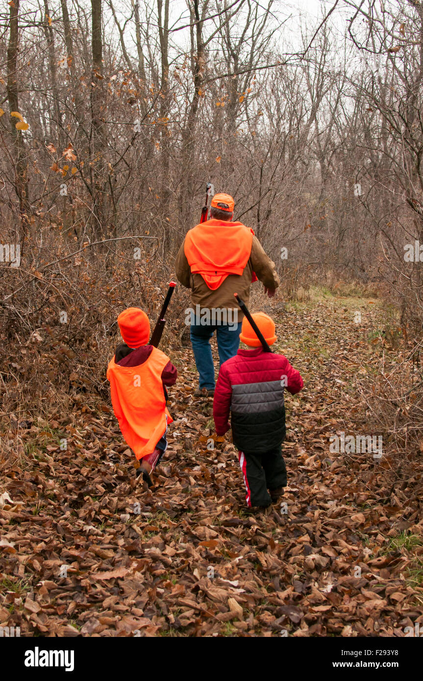 boys and dad practice hunt in woods Stock Photo