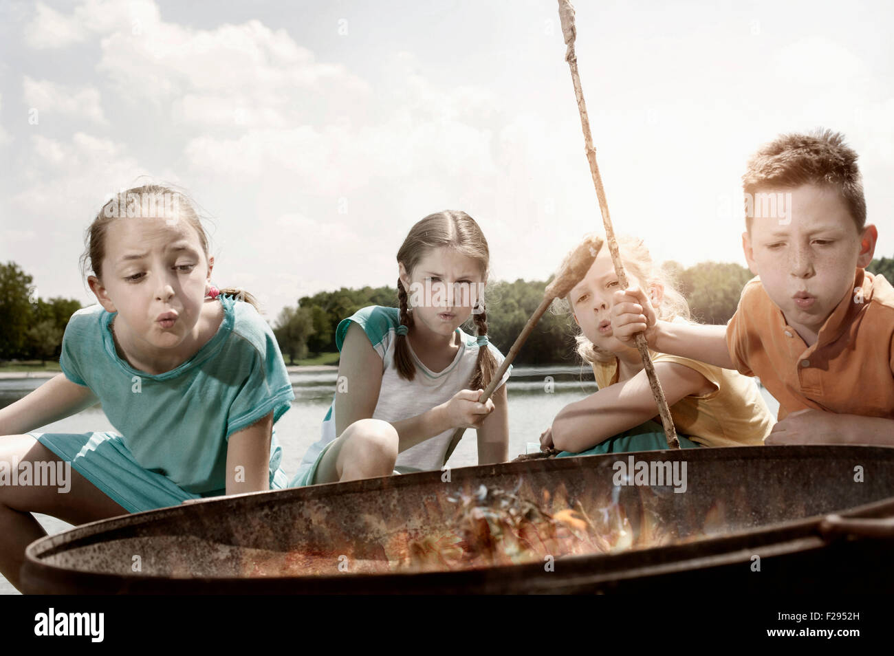 Group of friends preparing sausages on campfire, Bavaria, Germany Stock Photo