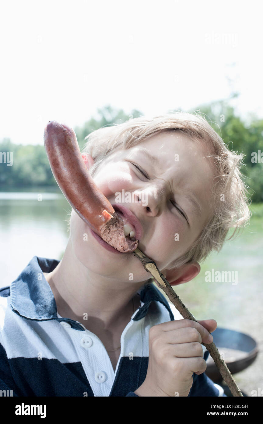 Close-up of a boy eating sausage, Bavaria, Germany Stock Photo