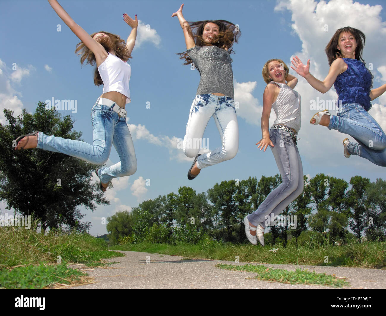 happy group of female students jumping in the village Stock Photo