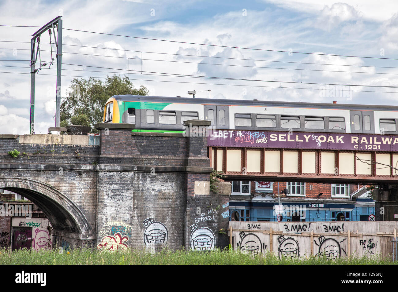 A London Midland train crossing the graffitied railway arches at Selly Oak, Birmingham, England, UK Stock Photo