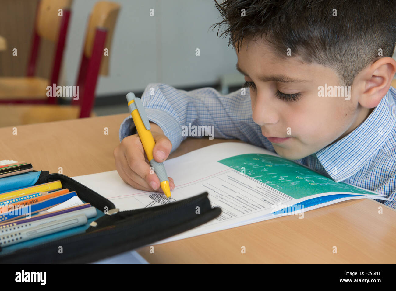 schoolboy taking exam in classroom, Munich, Bavaria, Germany Stock Photo