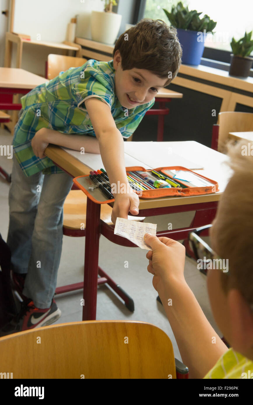 school students passing notes during exam in classroom, Munich, Bavaria, Germany Stock Photo