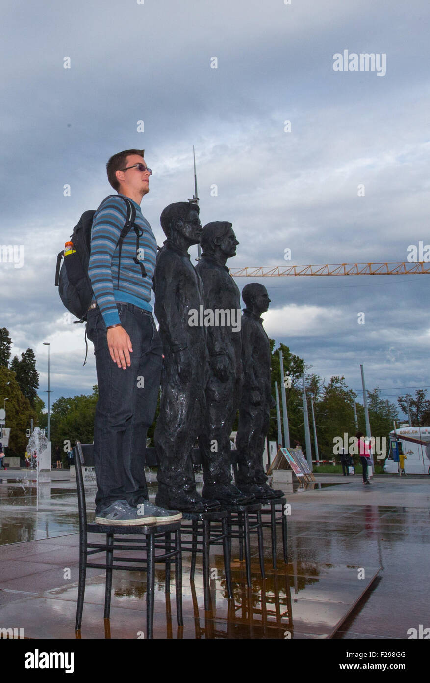 Geneva, Switzerland. 14th Sep, 2015. A visitor poses for photos with a sculpture titled 'Anything to Say?' and made up of life-size bronze figures of Edward Snowden, Julian Assange and Chelsea Manning on the Place des Nations in front of the European headquarters of the United Nations in Geneva, Switzerland, Sept. 14, 2015. The bronze figures, created by Italian sculptor Davide Dormino, will be exhibited on the square until Friday. © Xu Jinquan/Xinhua/Alamy Live News Stock Photo