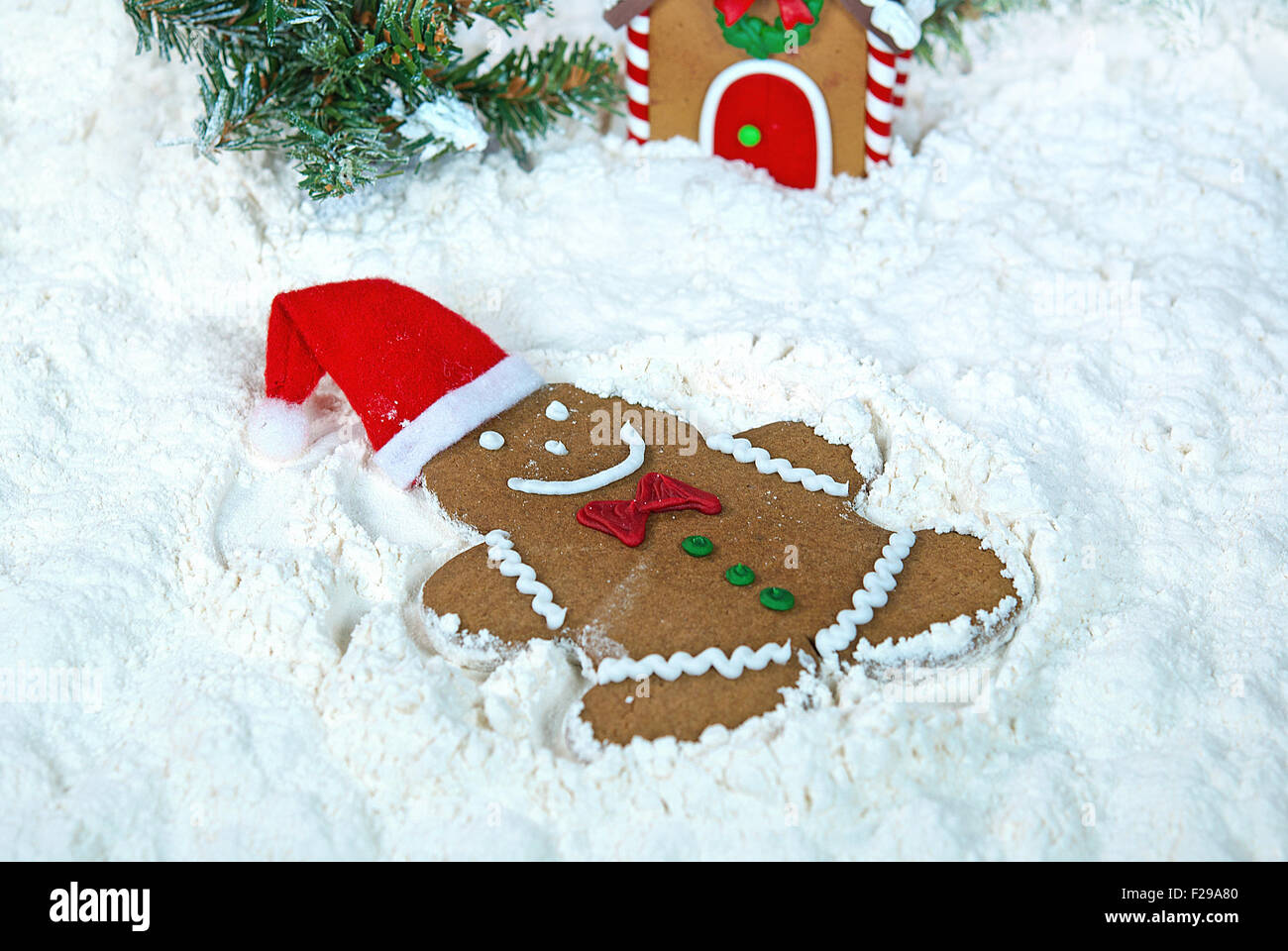 Christmas gingerbread man making an angel in white flour. Stock Photo
