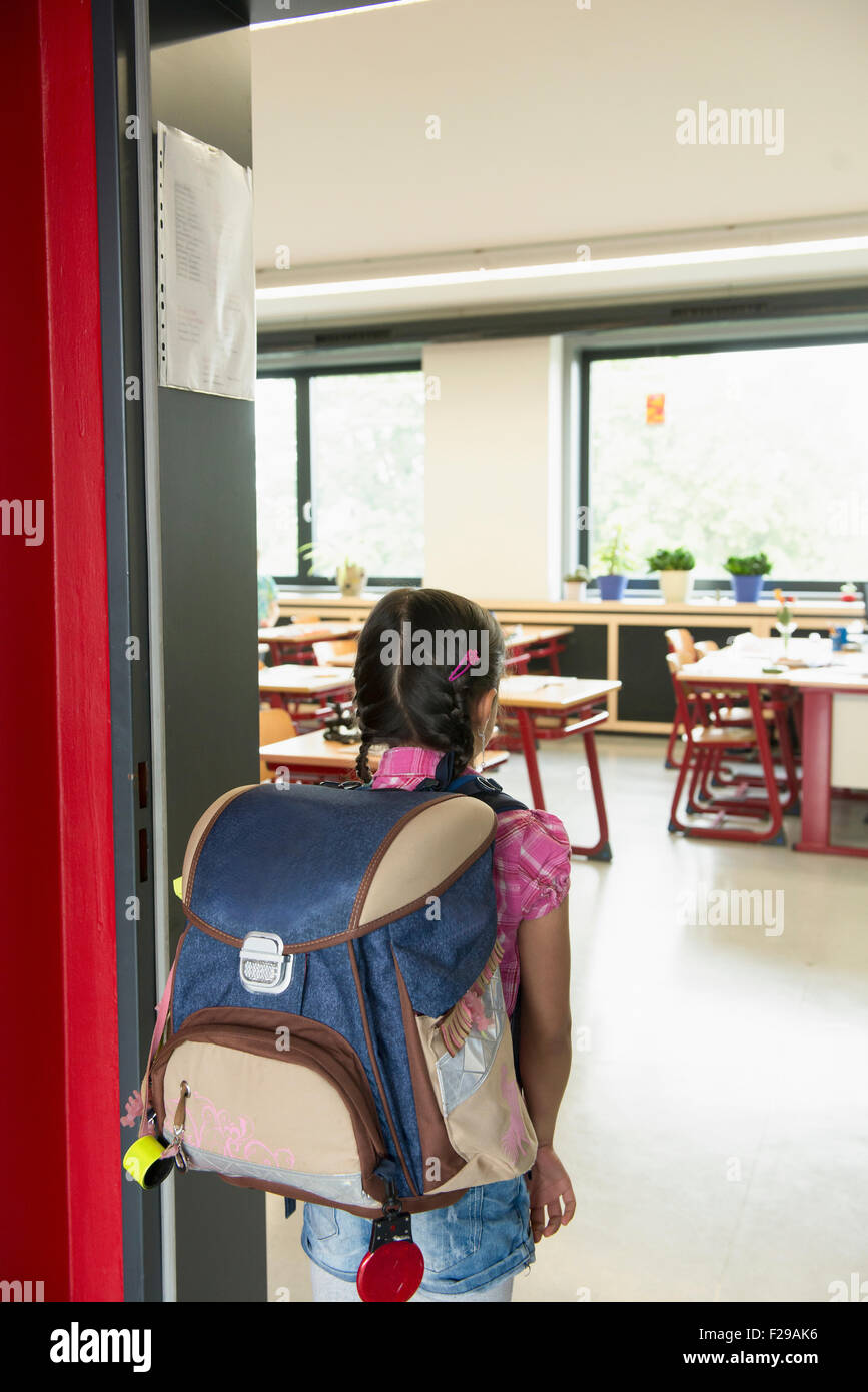 Rear view of a schoolgirl entering in classroom, Munich, Bavaria, Germany Stock Photo