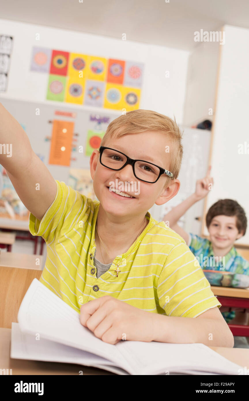 school children with raised hands in classroom, Munich, Bavaria ...